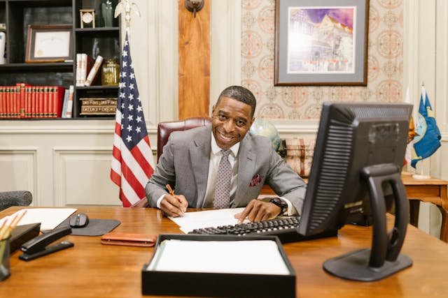 A Man in Gray Suit Jacket Sitting at the Table