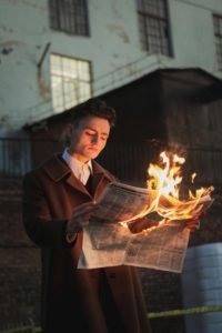boy reading a burning paper