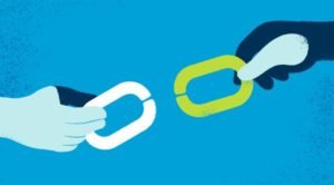 Two-hands-holding-linking-chain-pieces-on-blue-background)