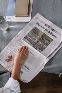 Person Reading News article On Table